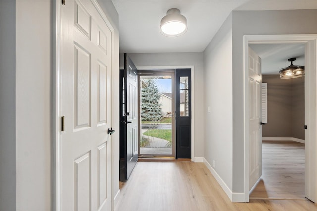 foyer entrance with light wood-type flooring and baseboards