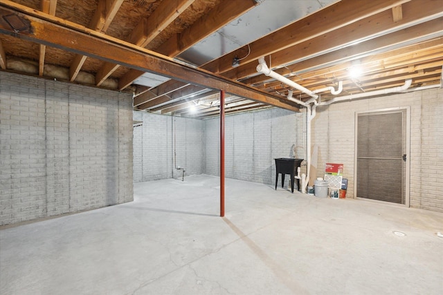 unfinished basement featuring brick wall