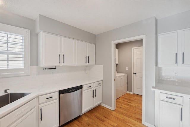 kitchen with washer and dryer, white cabinetry, dishwasher, and light wood-style flooring