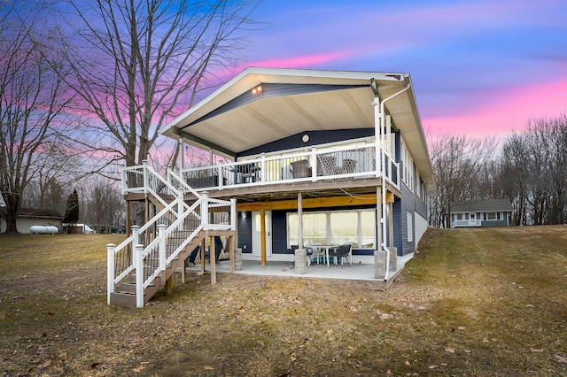 back of property with stairway, a patio area, a wooden deck, and a lawn