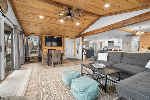 living area with recessed lighting, light wood-style flooring, lofted ceiling with beams, wood ceiling, and ceiling fan with notable chandelier