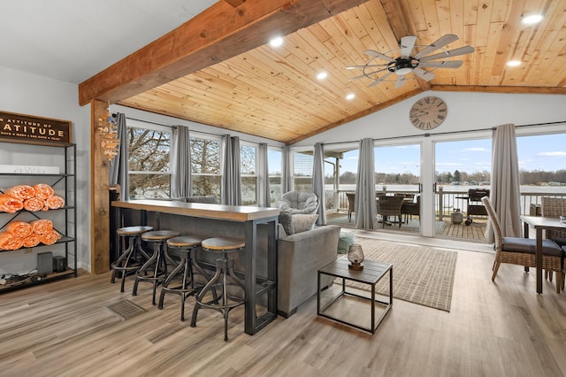 interior space with vaulted ceiling with beams, a bar, wood ceiling, and a ceiling fan