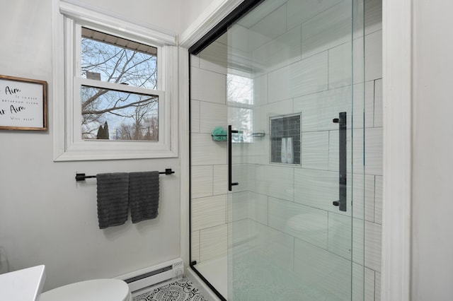 bathroom with toilet, a shower stall, and baseboard heating