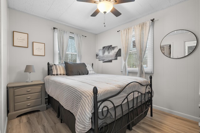 bedroom featuring ceiling fan, light wood finished floors, and baseboards