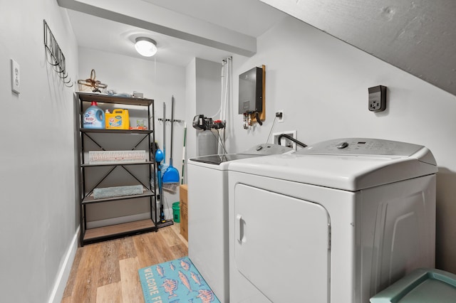 laundry area with laundry area, independent washer and dryer, light wood-style flooring, and baseboards