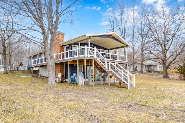 rear view of house featuring stairway, a chimney, and a wooden deck