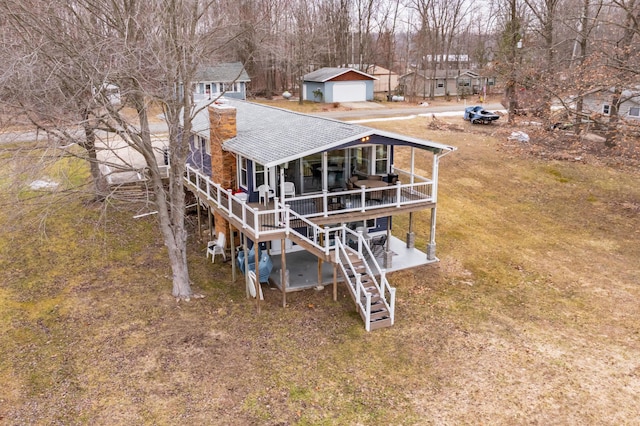 rear view of property featuring a garage, a shingled roof, and stairway