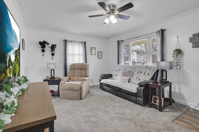 living area with a ceiling fan, crown molding, and baseboards