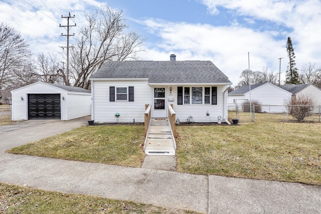 bungalow with driveway, a detached garage, an outbuilding, fence, and a front lawn