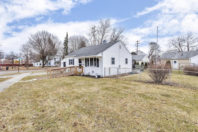 exterior space with roof with shingles, a front yard, fence, and a wooden deck