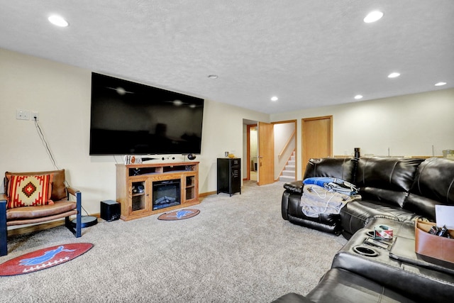 carpeted living area featuring a glass covered fireplace, stairway, a textured ceiling, and recessed lighting