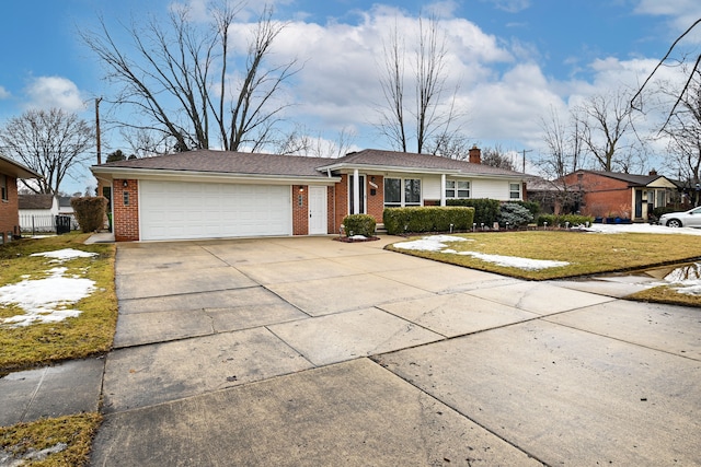 view of front of property with driveway, a garage, brick siding, a chimney, and a front yard