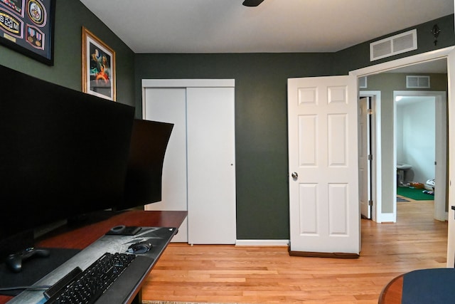 interior space with light wood finished floors, baseboards, and visible vents