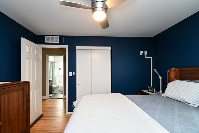 bedroom with a ceiling fan, visible vents, a closet, and wood finished floors