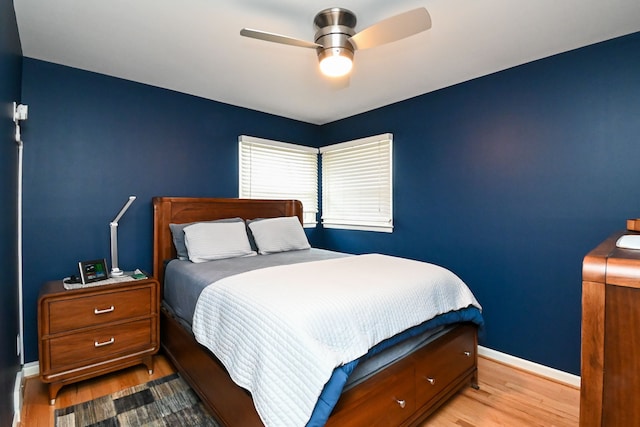 bedroom featuring ceiling fan, baseboards, and wood finished floors