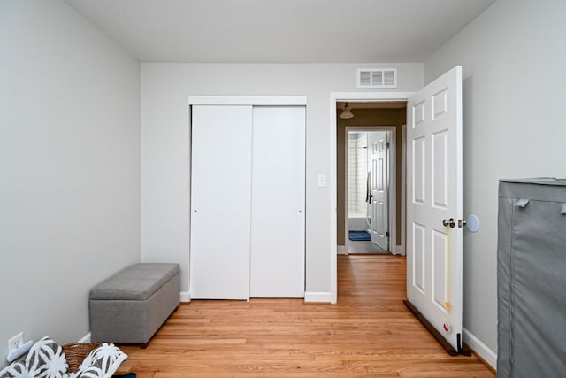 bedroom with light wood-style flooring, a closet, visible vents, and baseboards