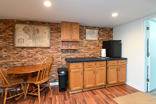 kitchen with light wood-type flooring, dark countertops, and recessed lighting