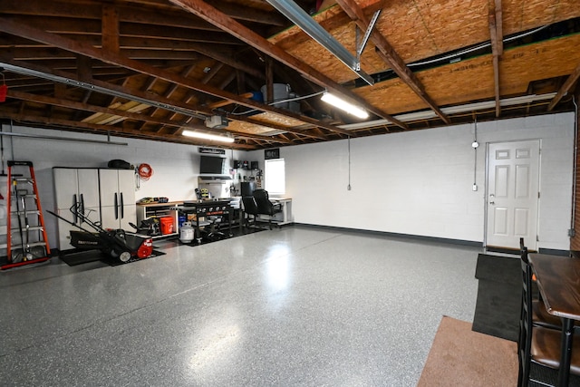 garage with concrete block wall and a garage door opener