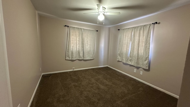 spare room with dark carpet, baseboards, and ceiling fan