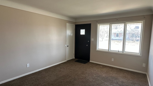 entrance foyer with dark carpet and baseboards