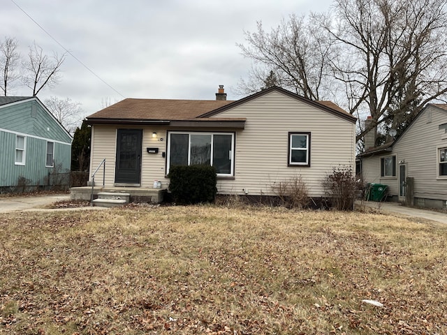 view of front of house featuring a front lawn and a chimney