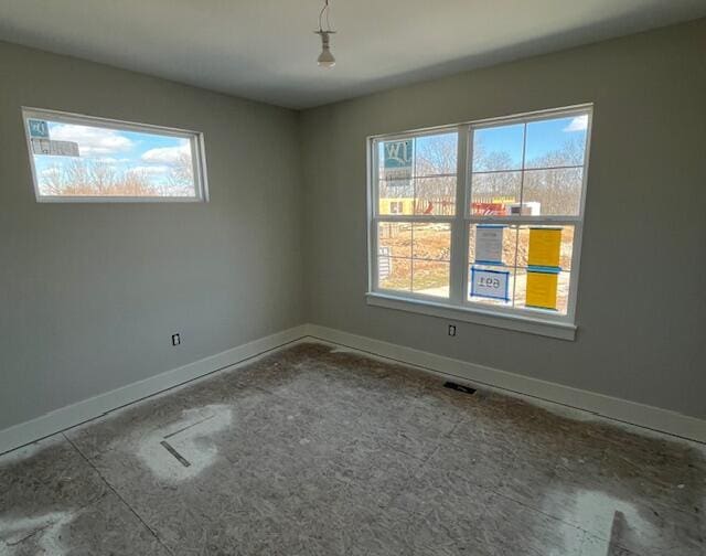 spare room with visible vents, baseboards, and a wealth of natural light