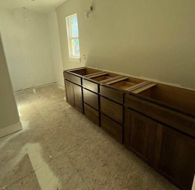 interior space featuring dark brown cabinets and dark countertops