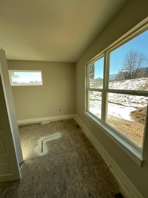 spare room featuring plenty of natural light and baseboards