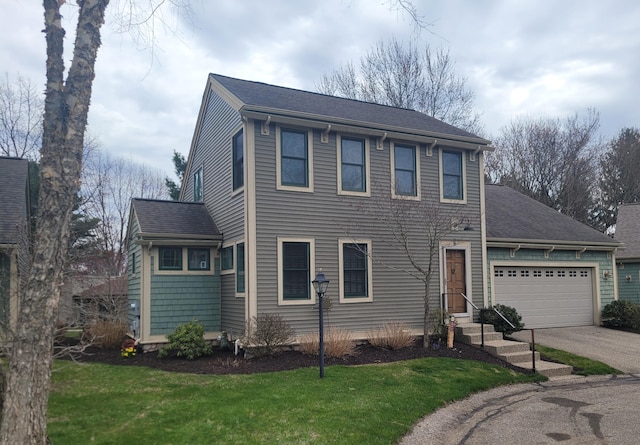 colonial inspired home featuring a shingled roof, a front lawn, aphalt driveway, and a garage