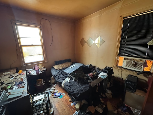 bedroom featuring cooling unit and wood finished floors