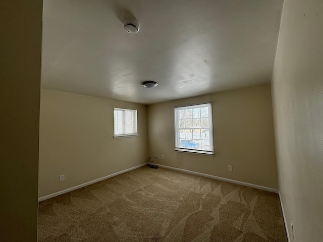 carpeted spare room with baseboards