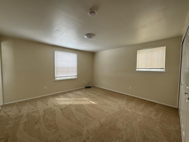 spare room with carpet and baseboards