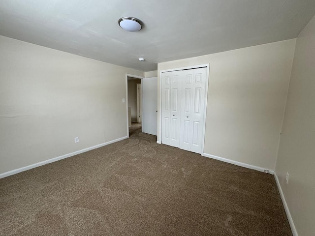 unfurnished bedroom with carpet, baseboards, and a closet