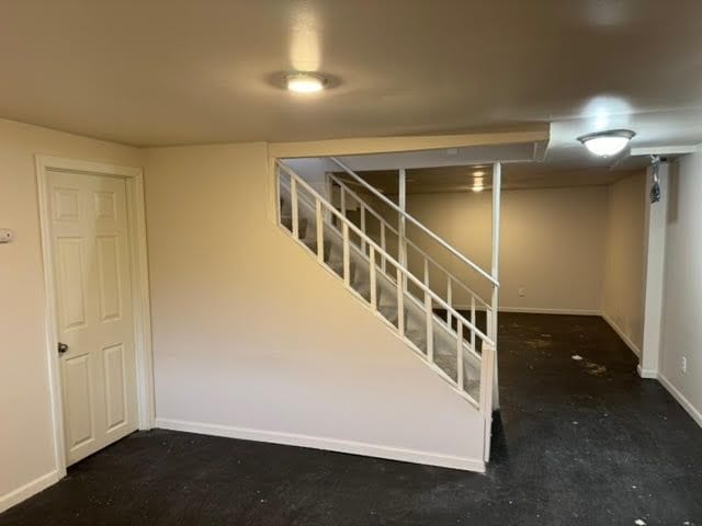 finished basement with stairs and baseboards