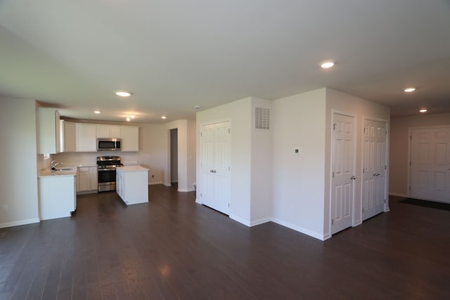 kitchen with visible vents, white cabinets, light countertops, appliances with stainless steel finishes, and dark wood-style floors