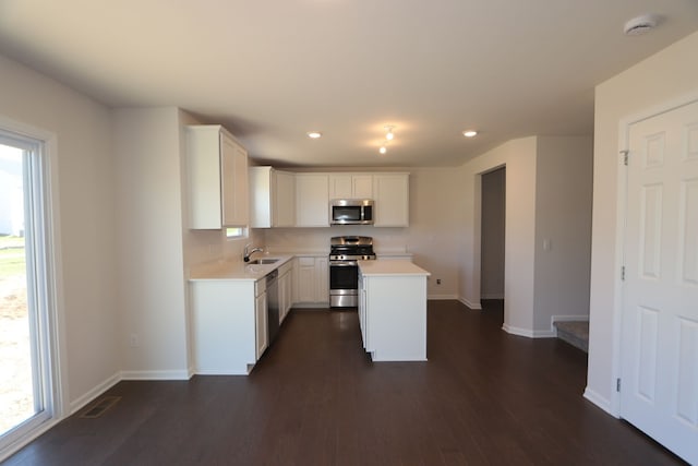 kitchen featuring dark wood-type flooring, appliances with stainless steel finishes, light countertops, and a sink