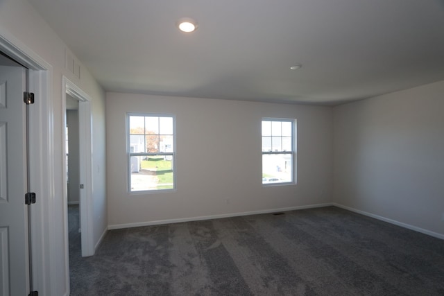 spare room featuring baseboards, a healthy amount of sunlight, and carpet flooring