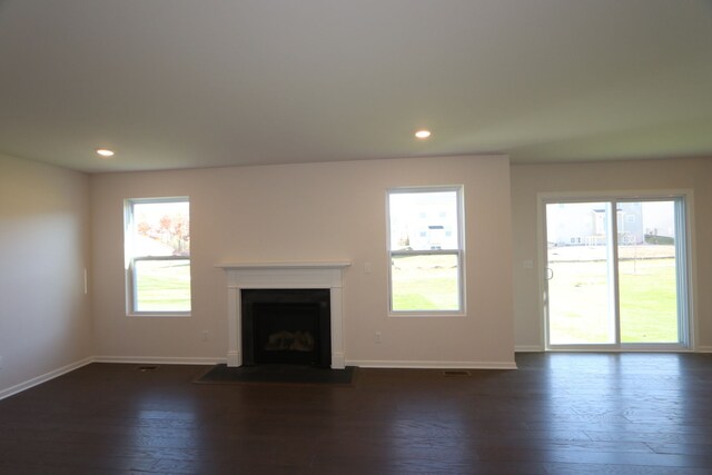 unfurnished living room with a fireplace with flush hearth, recessed lighting, dark wood-style flooring, and baseboards