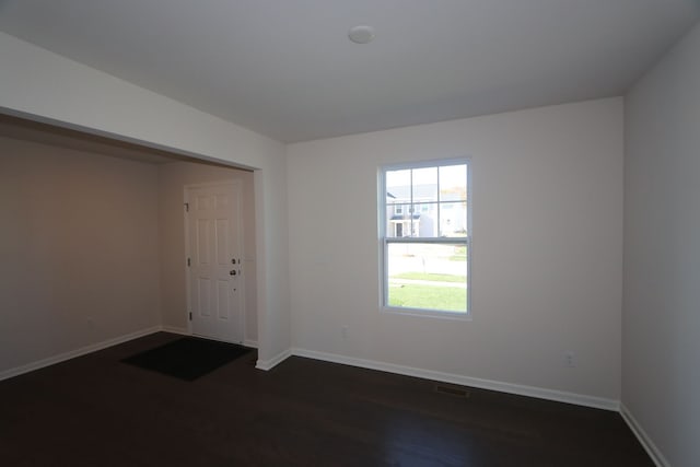 foyer featuring dark wood finished floors, visible vents, and baseboards