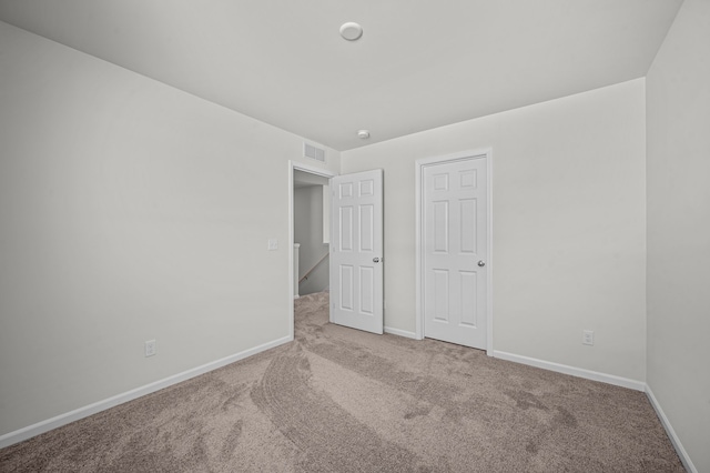 unfurnished bedroom with visible vents, carpet flooring, and baseboards