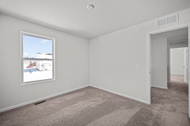 carpeted spare room with baseboards and visible vents