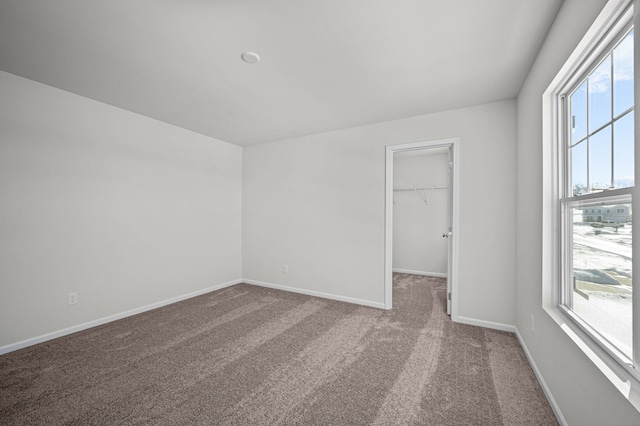 carpeted empty room with baseboards