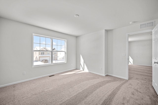 carpeted spare room featuring visible vents and baseboards