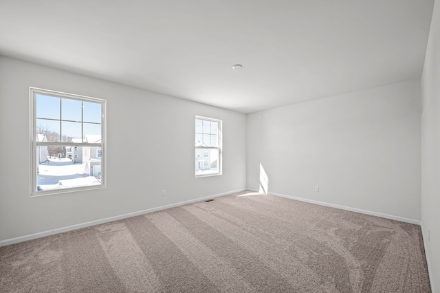 empty room featuring baseboards and carpet floors