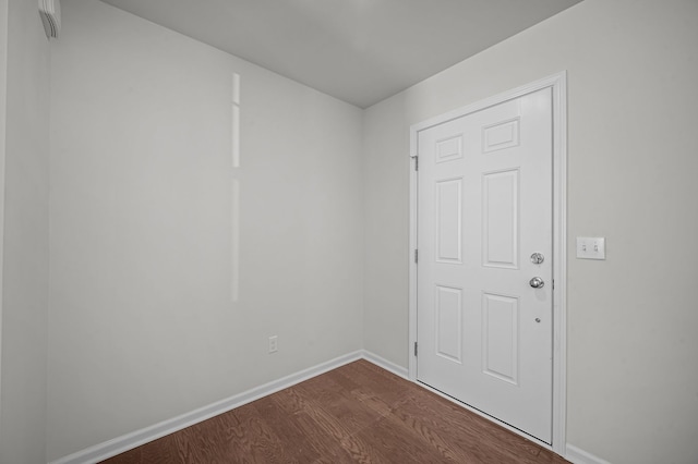 unfurnished room featuring dark wood finished floors and baseboards