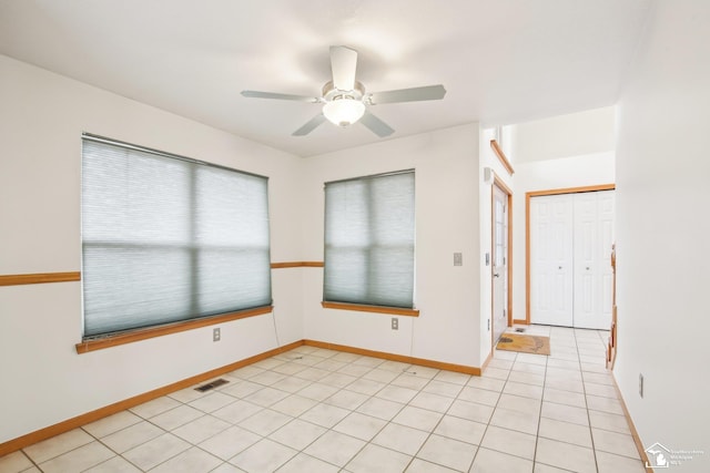 unfurnished room featuring baseboards, visible vents, a ceiling fan, and light tile patterned flooring