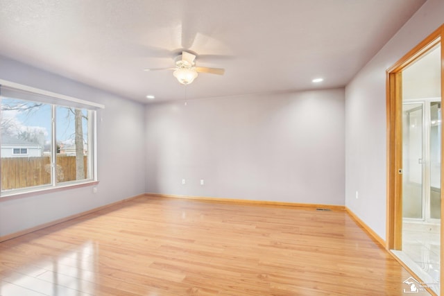 spare room featuring a ceiling fan, recessed lighting, light wood-style flooring, and baseboards