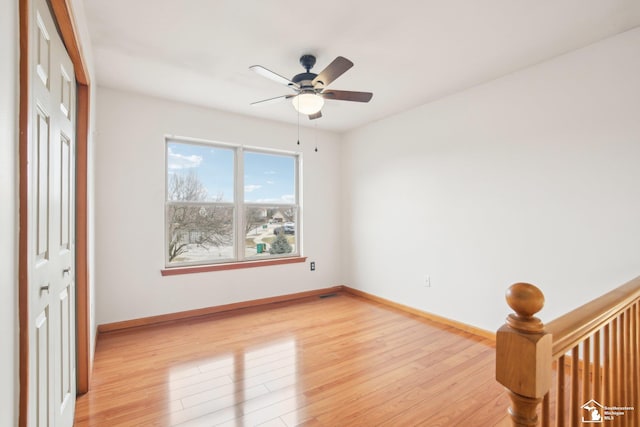 unfurnished bedroom featuring ceiling fan, light wood finished floors, and baseboards