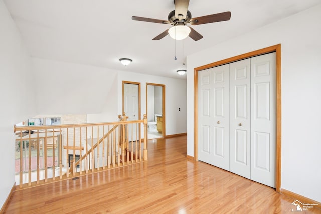 interior space featuring baseboards, wood finished floors, and an upstairs landing