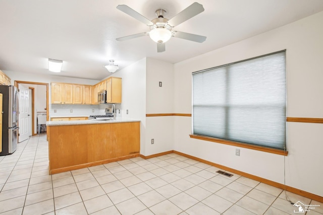 kitchen with light countertops, visible vents, appliances with stainless steel finishes, light brown cabinets, and a peninsula